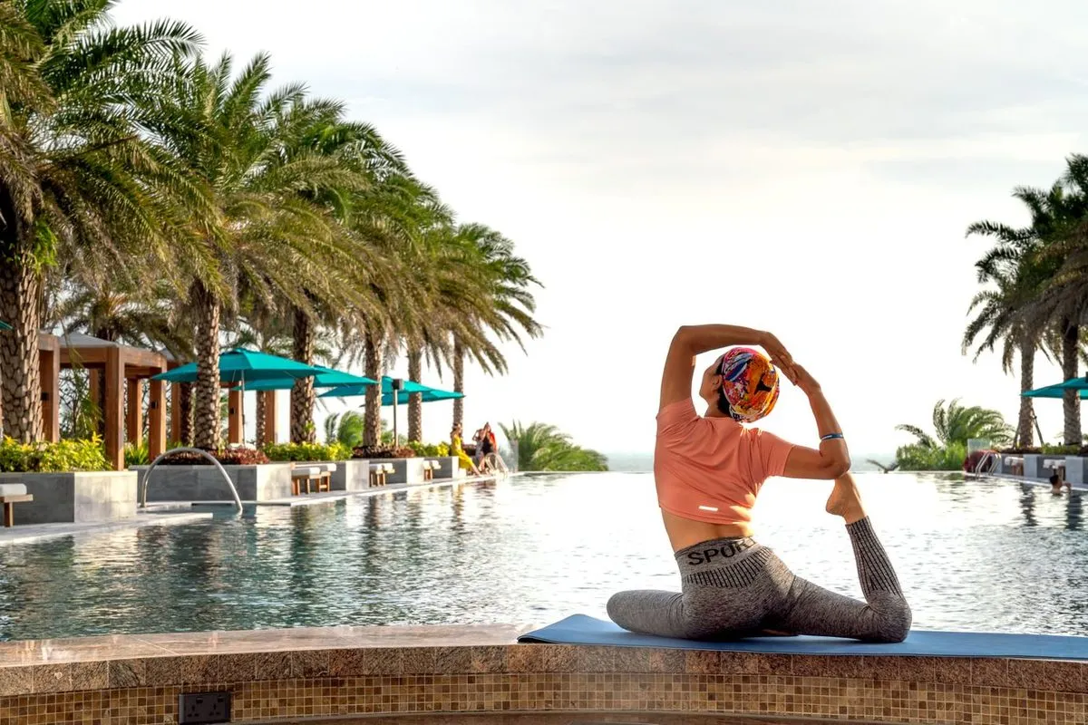 Femme en séance de yoga au bord d'une piscine