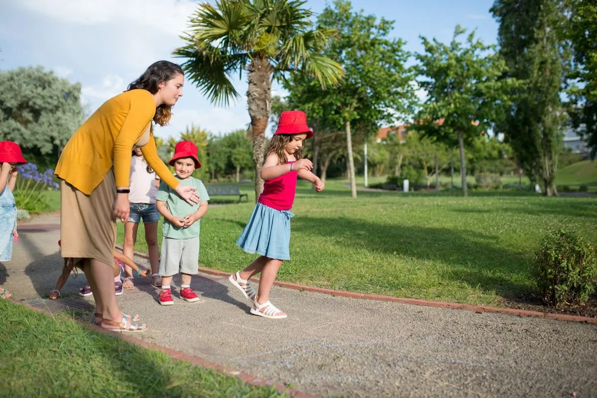 Une nounou et des enfants jouant dans un jardin ensoleillé