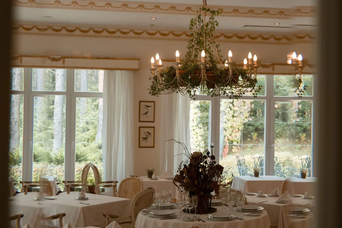 Salle de restaurant élégante avec lustre et tables dressées